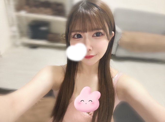 東京メンズエステのセラピスト・ちな｜ルームでリラックス、ピンクのキャミソール姿で可愛い笑顔を見せる20歳アイドル系セラピスト