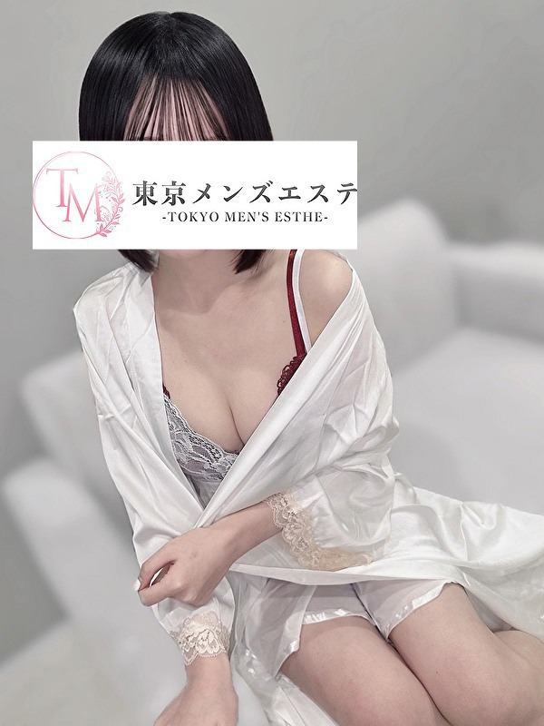 白いガウンを羽織り、ソファに腰掛けて穏やかな視線を向ける女性セラピストの姿